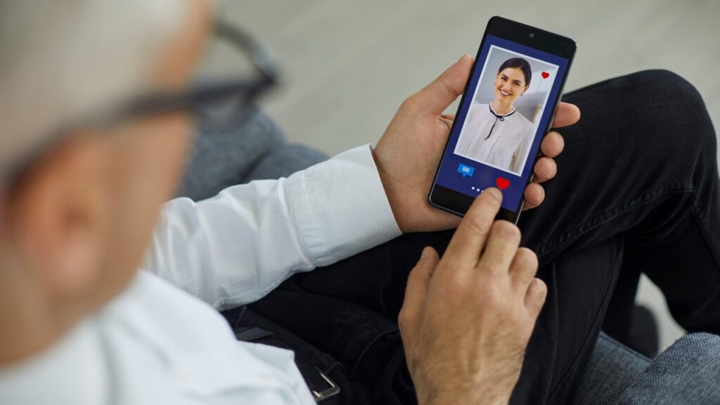 Homem mais velho clicando em coração na tela do celular